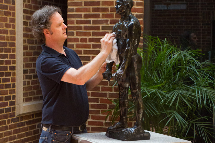 man cleaning statues